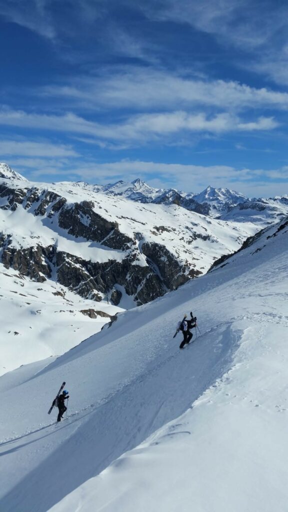 Skitourengeher im Frühling an einem schneebedeckten Hang des Mont Jovet mit Panoramablick auf die Alpen.